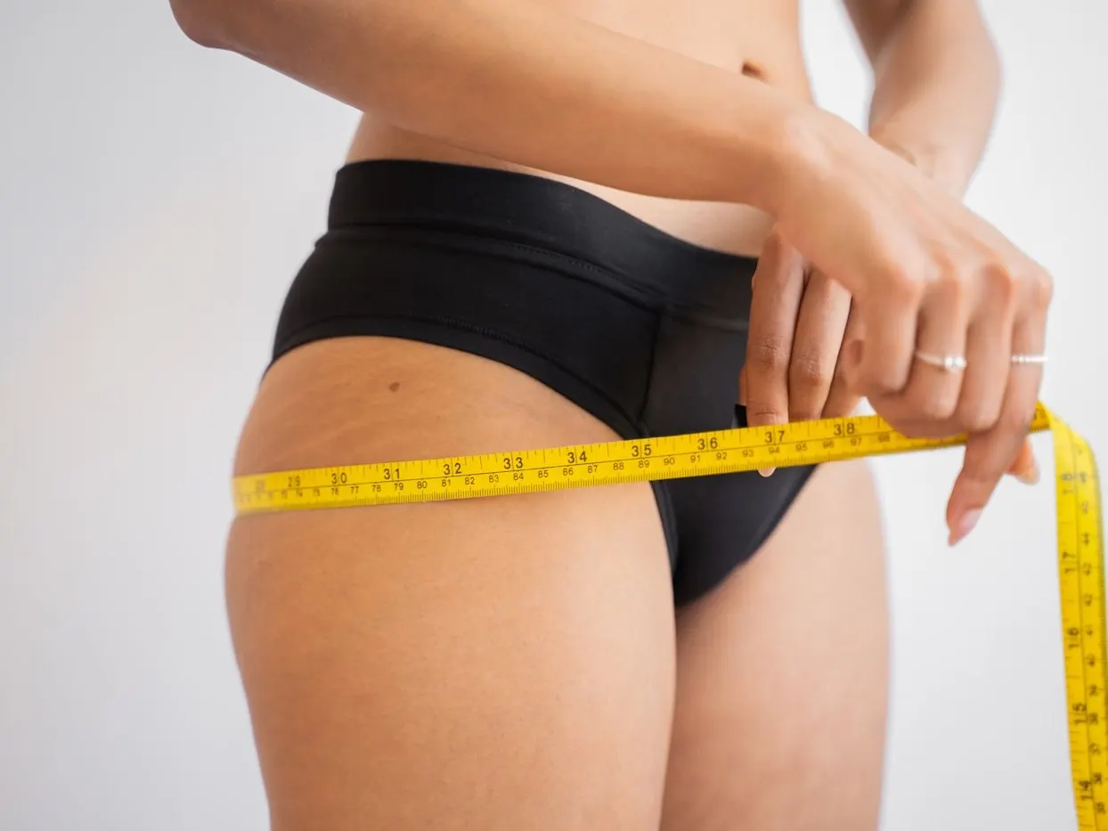 A tape measure being drawn around a patient's waist