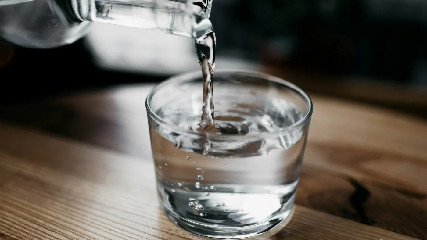 Water being poured into a glass in bright light