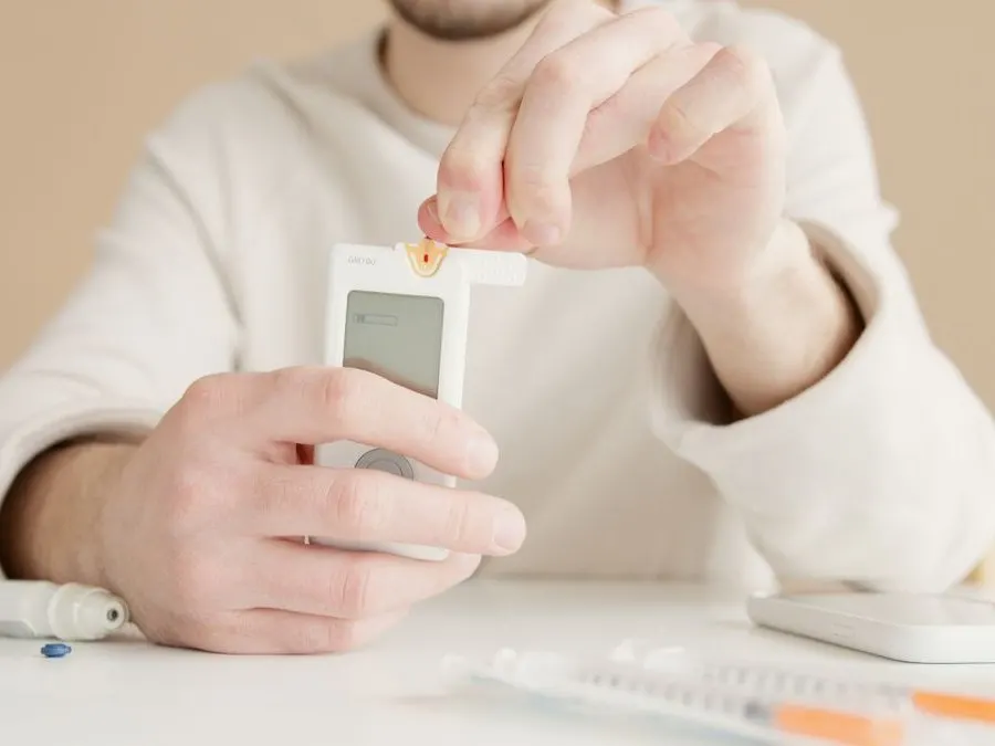 A blood glucose meter and lancet held in a patient's hands