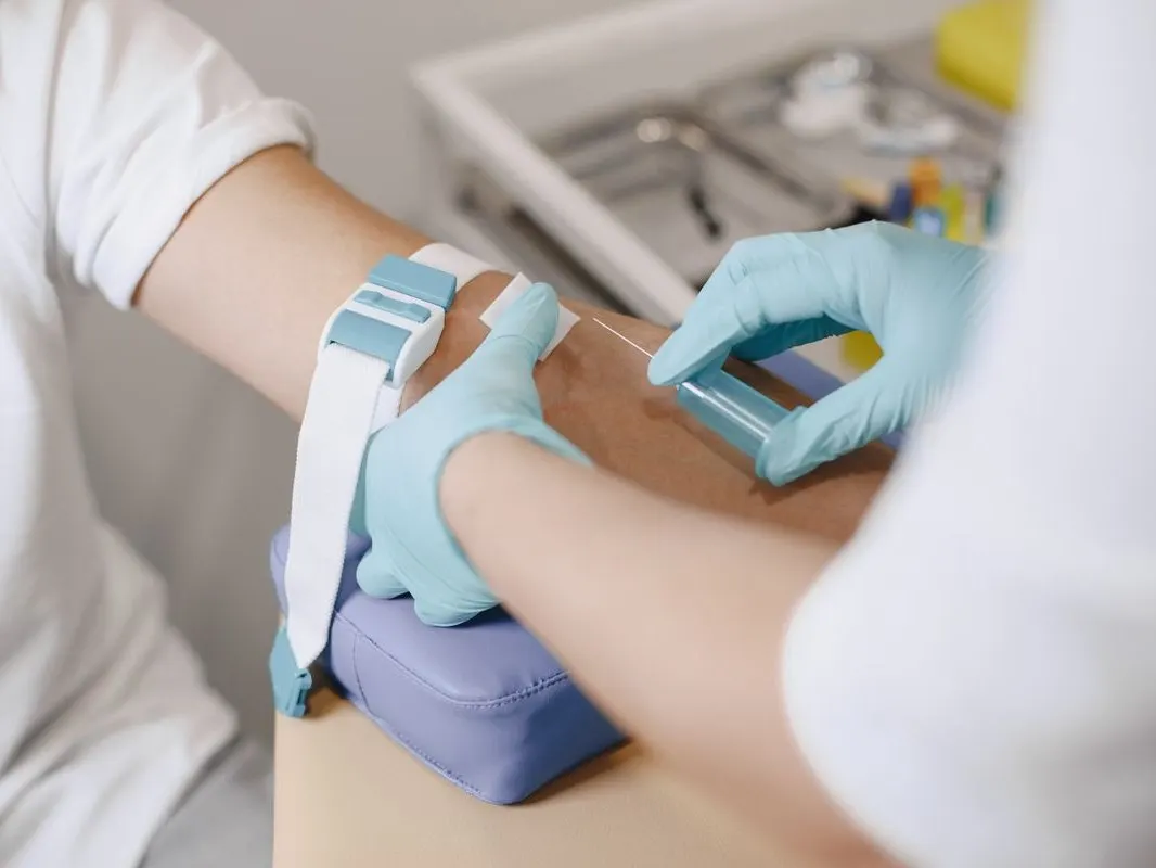 A phlebotomist drawing a blood sample from a patient's arm