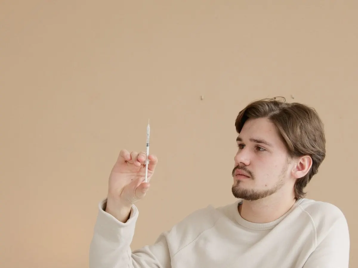 A patient preparing a weight loss injection at a table at home