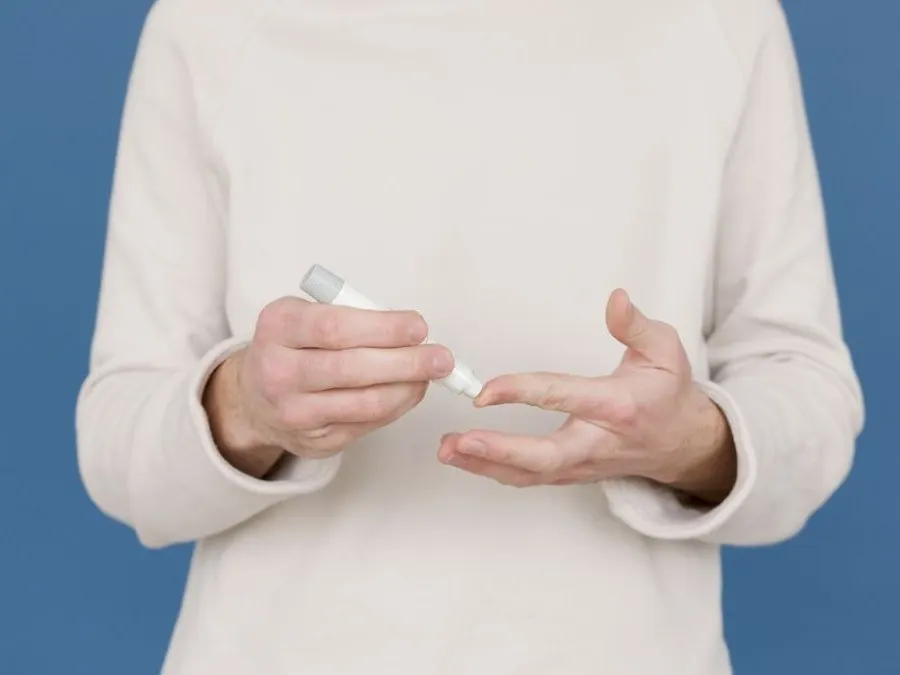 A patient holding a weight loss injection pen, ready to dose