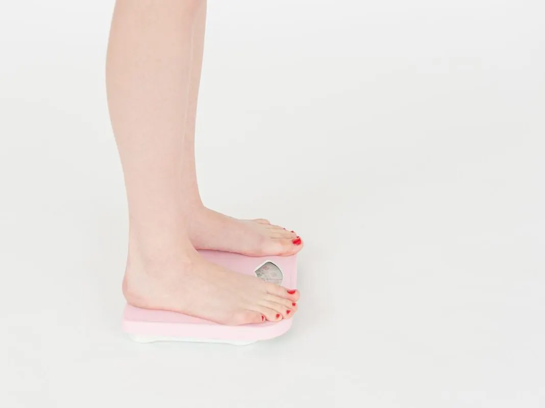 A person stepping onto a bathroom scale