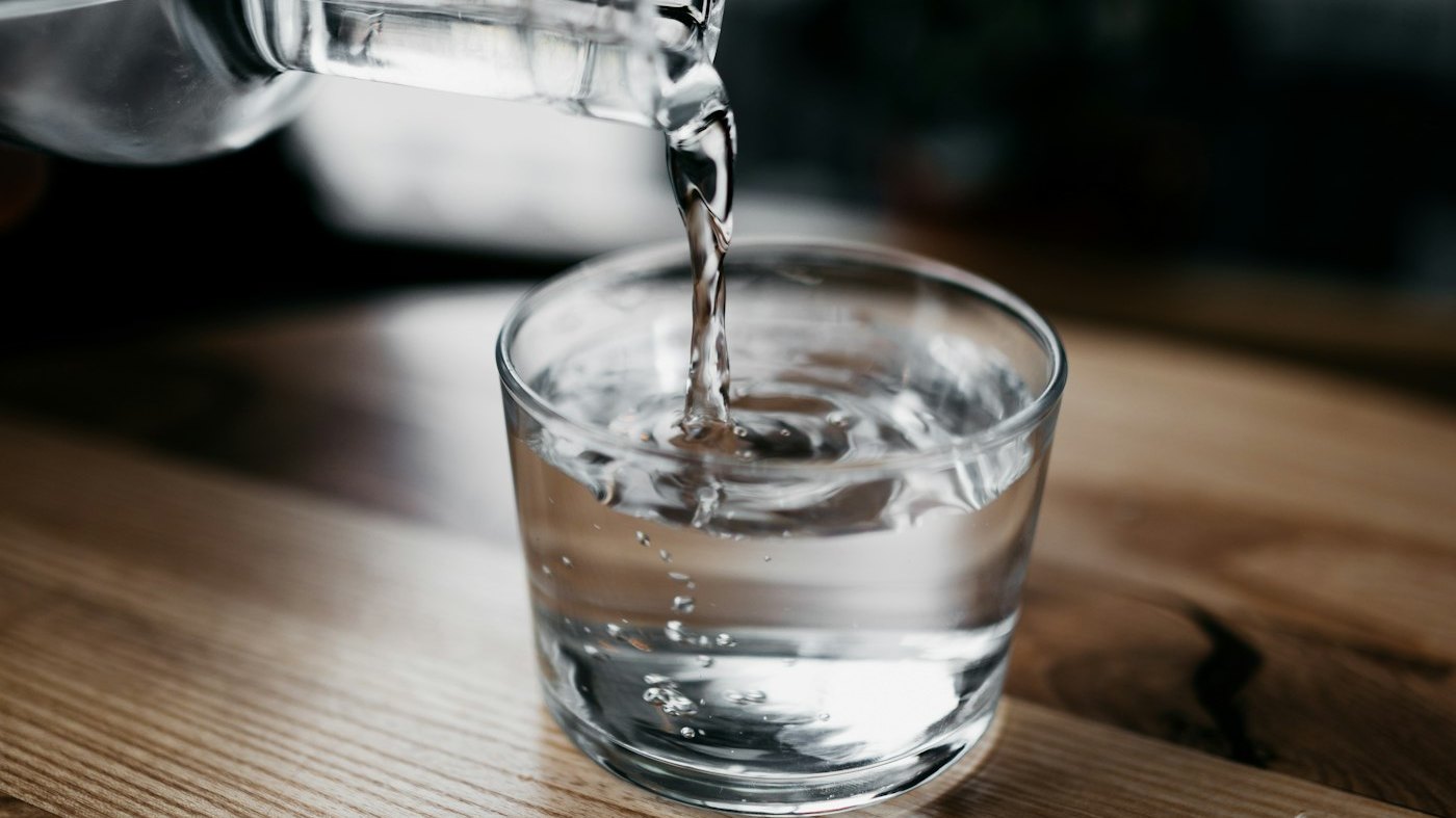 Water being poured into a glass in bright light
