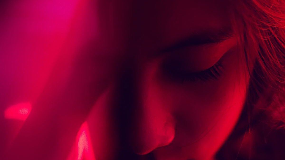 A person bathed in deep red therapy light