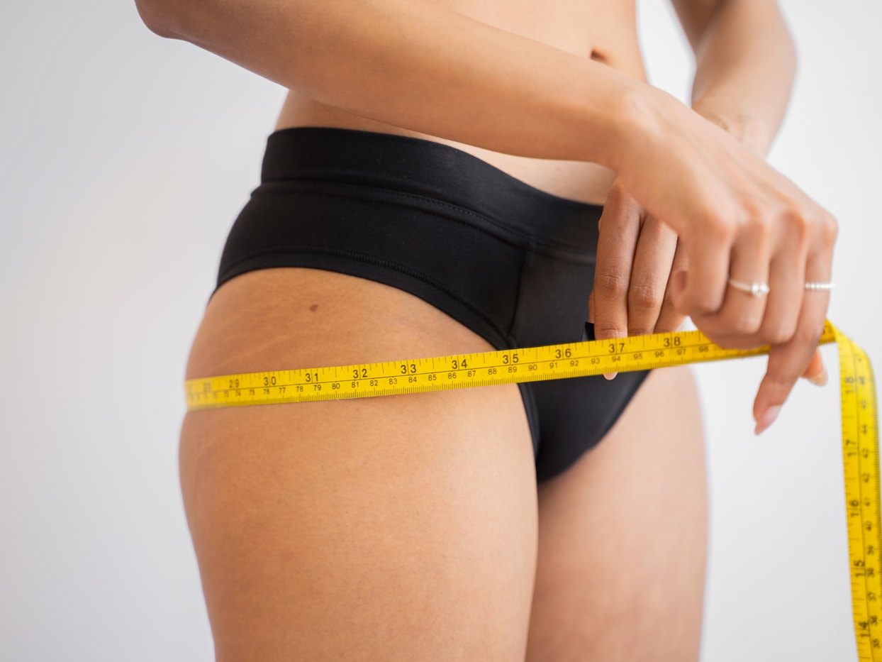 A tape measure being drawn around a patient's waist