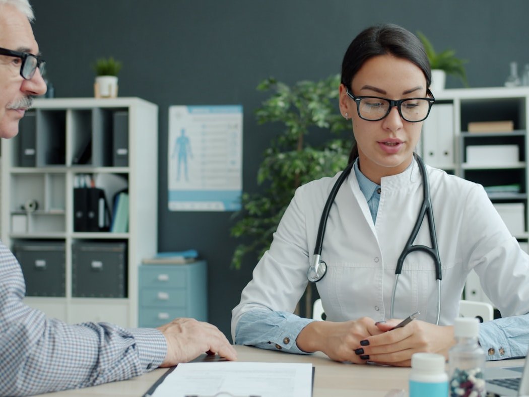 A clinician reviewing a patient's ongoing plan with them at a desk