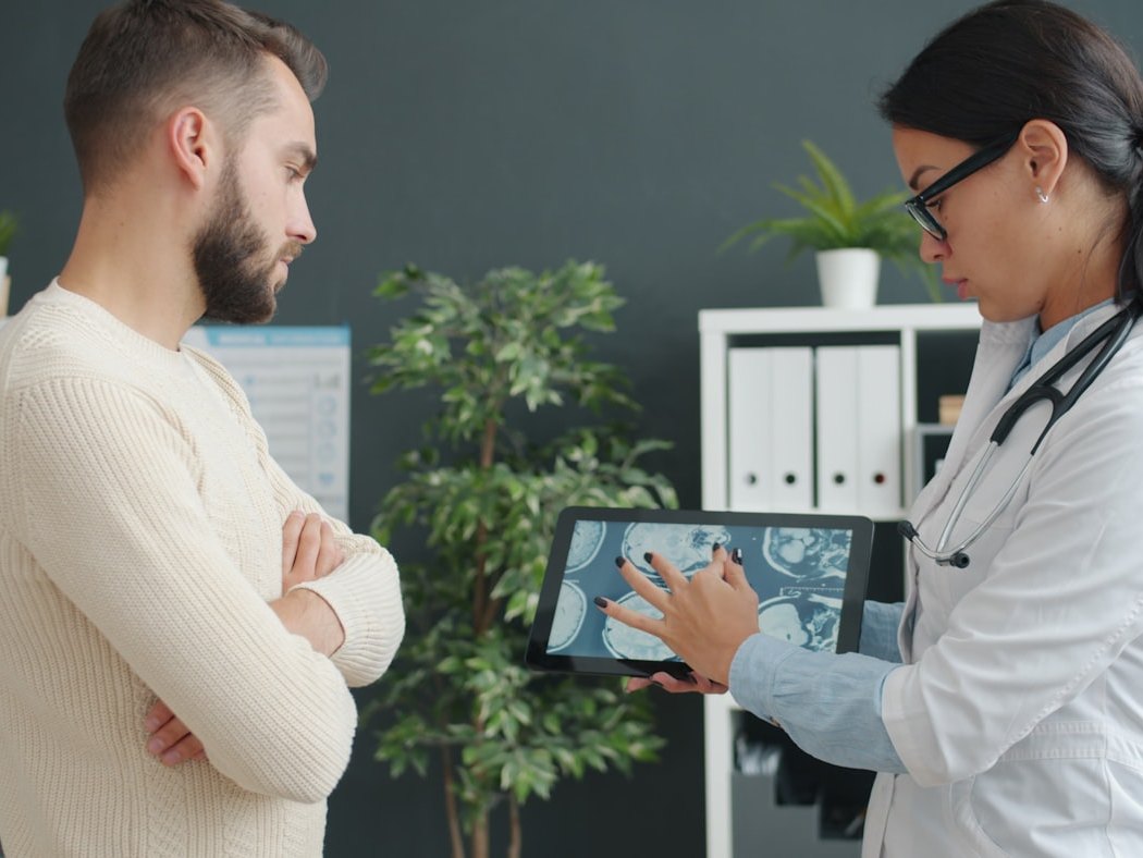 A clinician showing a patient their treatment plan on a tablet