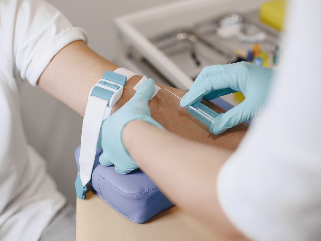 A phlebotomist drawing a blood sample from a patient's arm