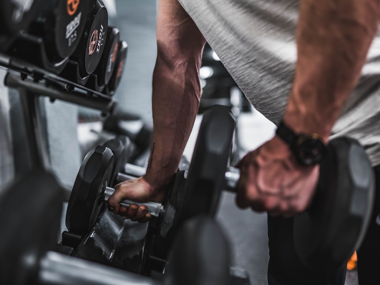 Hands gripping a dumbbell mid-set during a strength workout