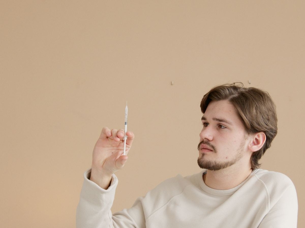 A patient preparing a weight loss injection at a table at home