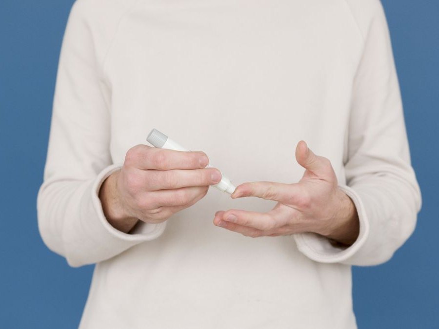 A patient holding a weight loss injection pen, ready to dose
