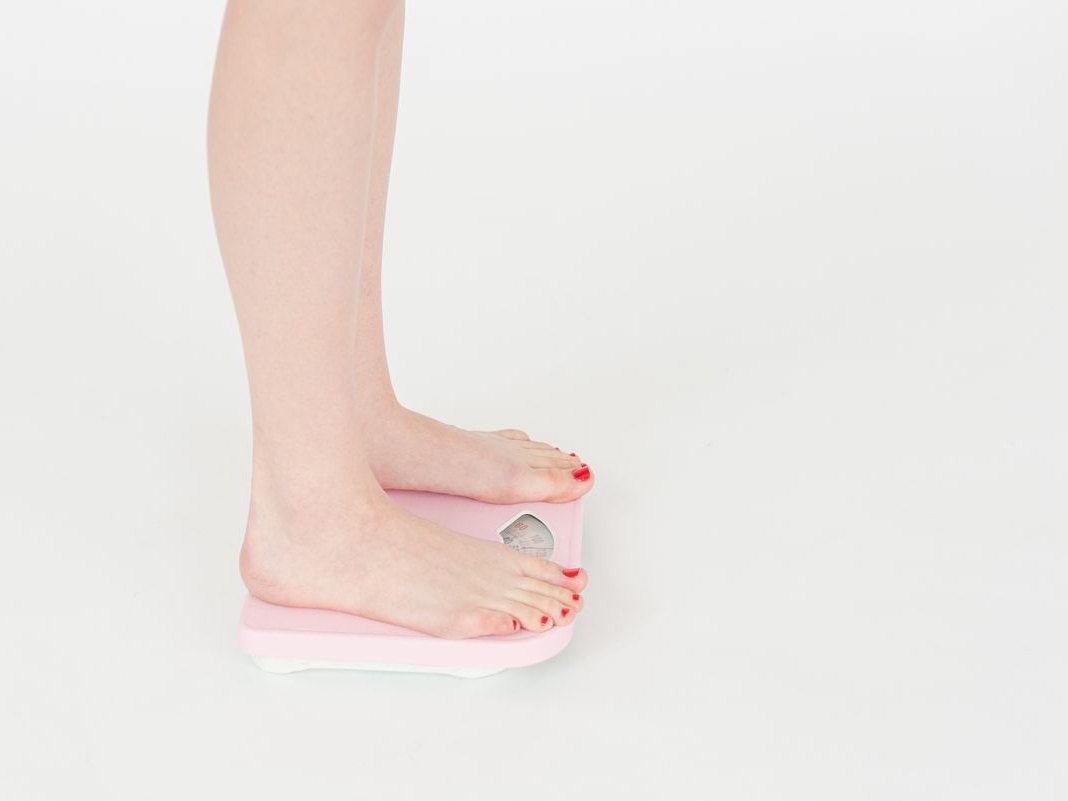 A person stepping onto a bathroom scale